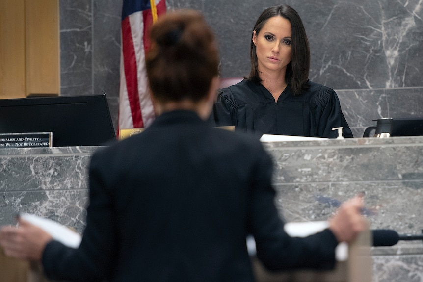 Judge Elizabeth Scherer looks over a courtroom with a serious expression on her face. 
