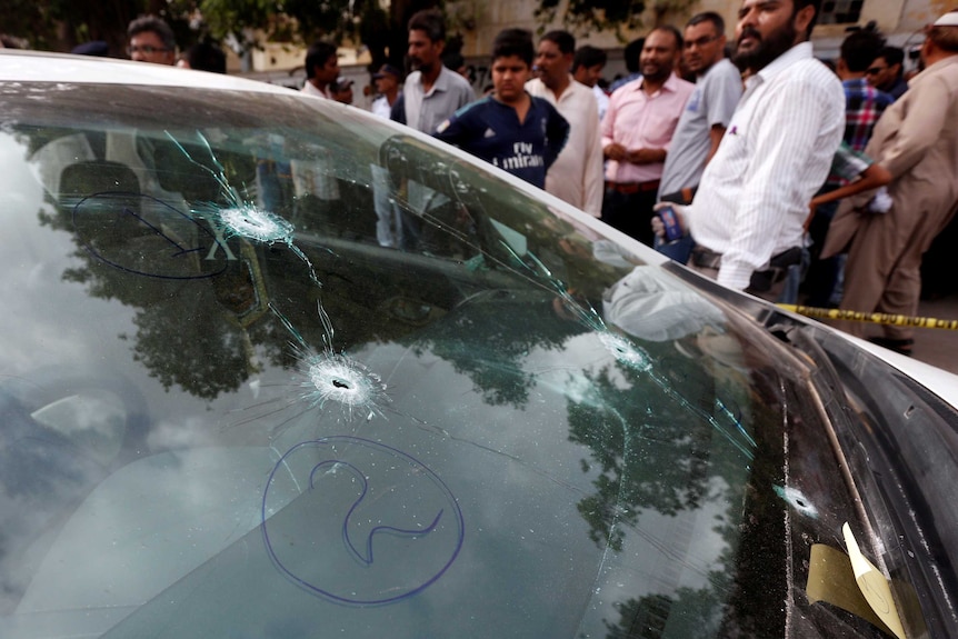 Bullet holes in the windscreen of a car driven by Amjad Sabri.