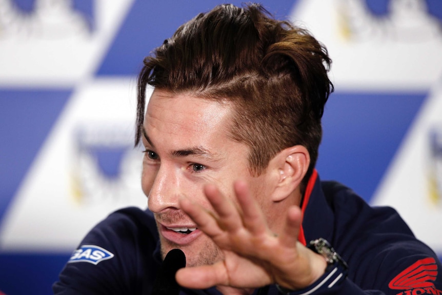 Honda MotoGP rider Nicky Hayden holds up his hand during a press conference.