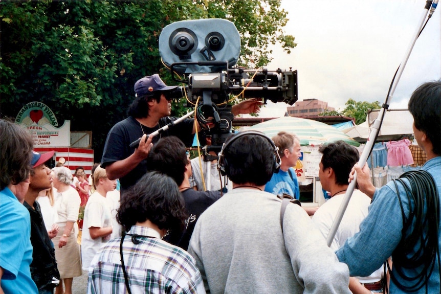 Camera crew film in a market