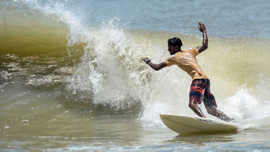 A surfing turning on a wave.