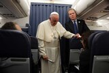 Pope Francis and Vatican spokesperson Greg Burke listen to a question during a press conference aboard a flight to Rome.