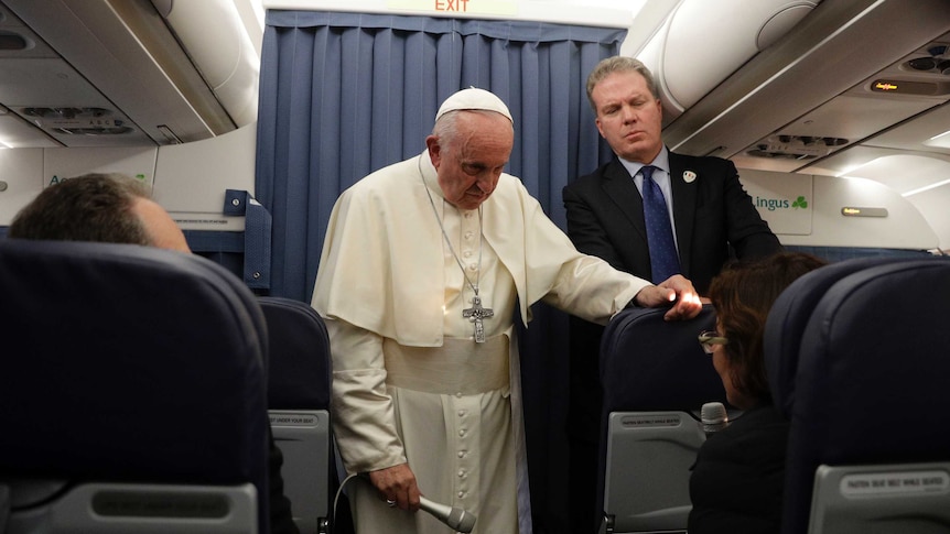 Pope Francis and Vatican spokesperson Greg Burke listen to a question during a press conference aboard a flight to Rome.