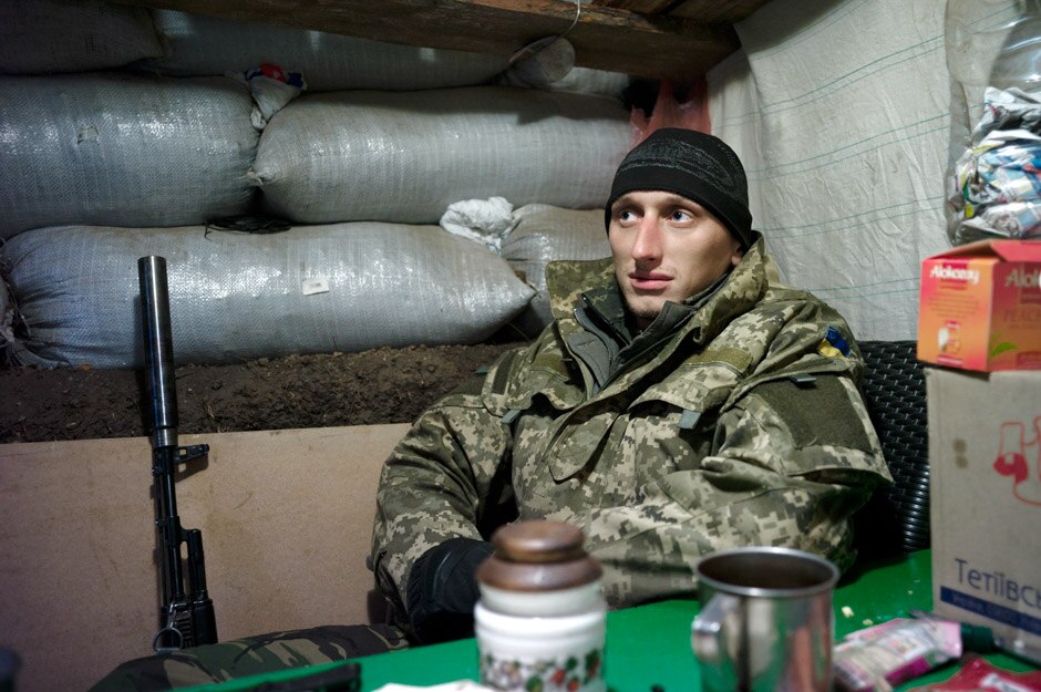 A Marine rests in his position’s canteen, having come inside to warm himself near the camp's wood oven.