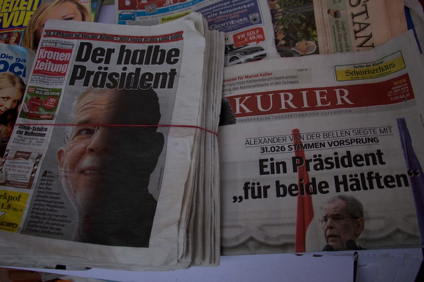 The photo shows Austrian newspapers with stories about Alexander Van Der Bellen on the front page.