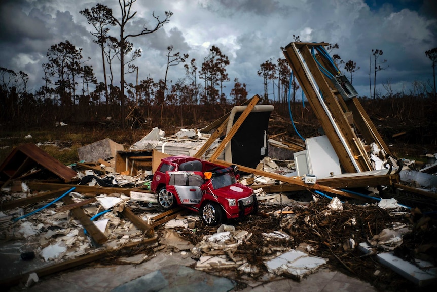 A red toy fire engine sits in the rubble of a house destroyed by Hurricane Dorian.