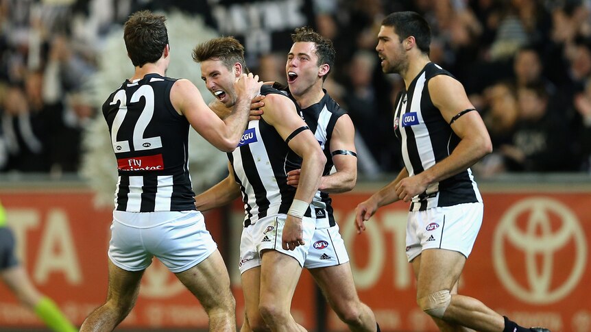 Collingwood players congratulate Dale Thomas after he kicked one of three goals for the night.