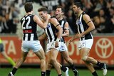 Collingwood players congratulate Dale Thomas after he kicked one of three goals for the night.