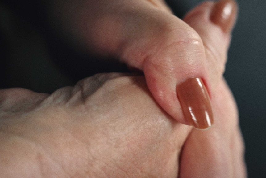 A still from Hoda Afshar's video work Agonistes, a close up shot of a white wrinkled skin and a blue eye