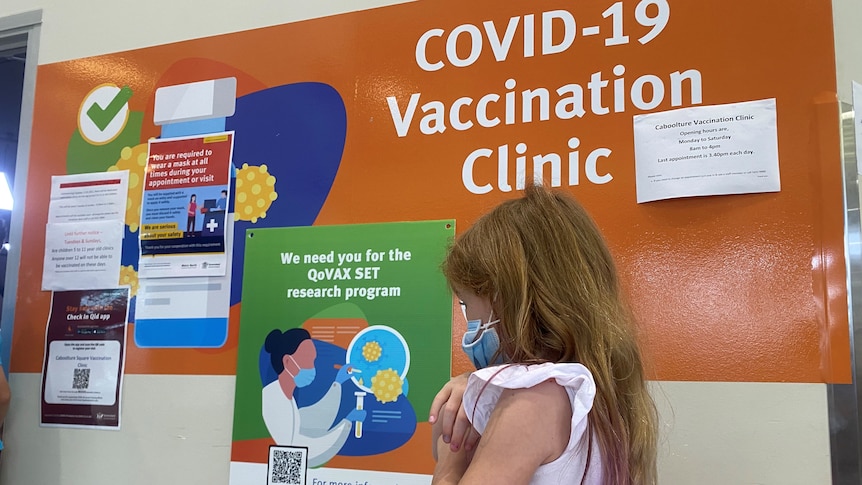 Little girl in bright dress lining up for COVID vaccine