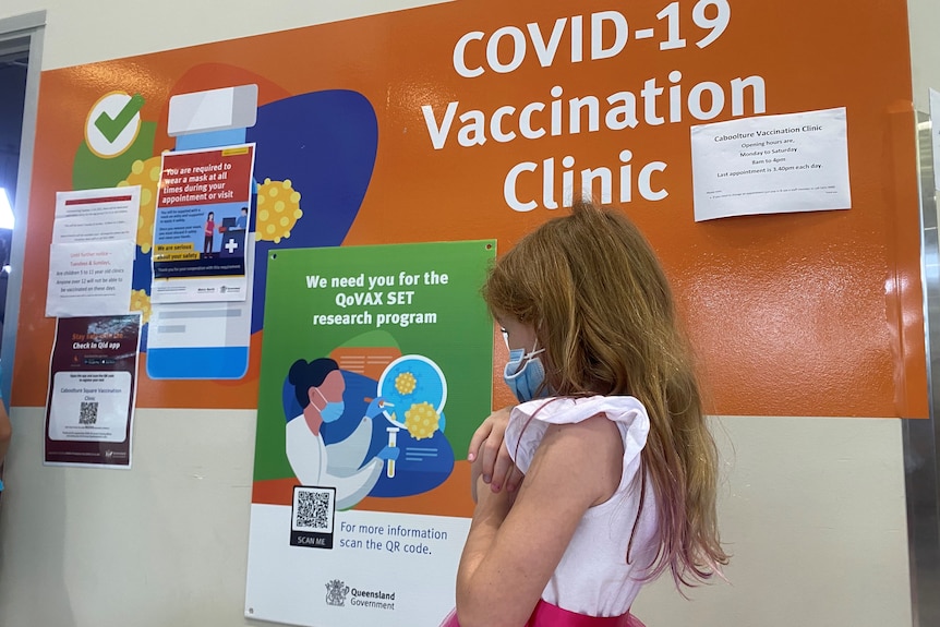 Little girl in bright dress lining up for COVID vaccine
