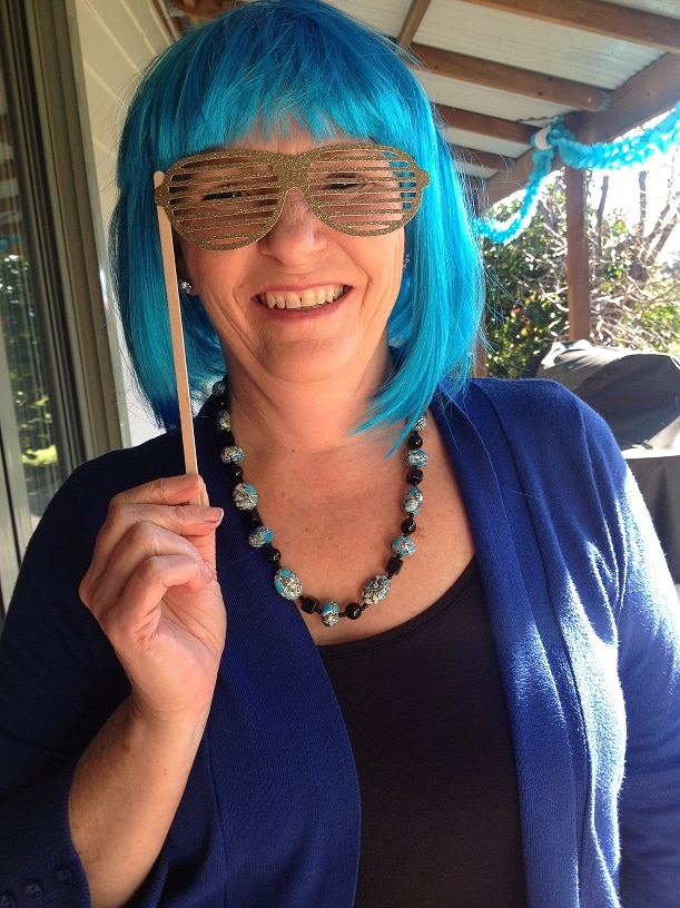 Tracey wears a blue wig and novelty glasses