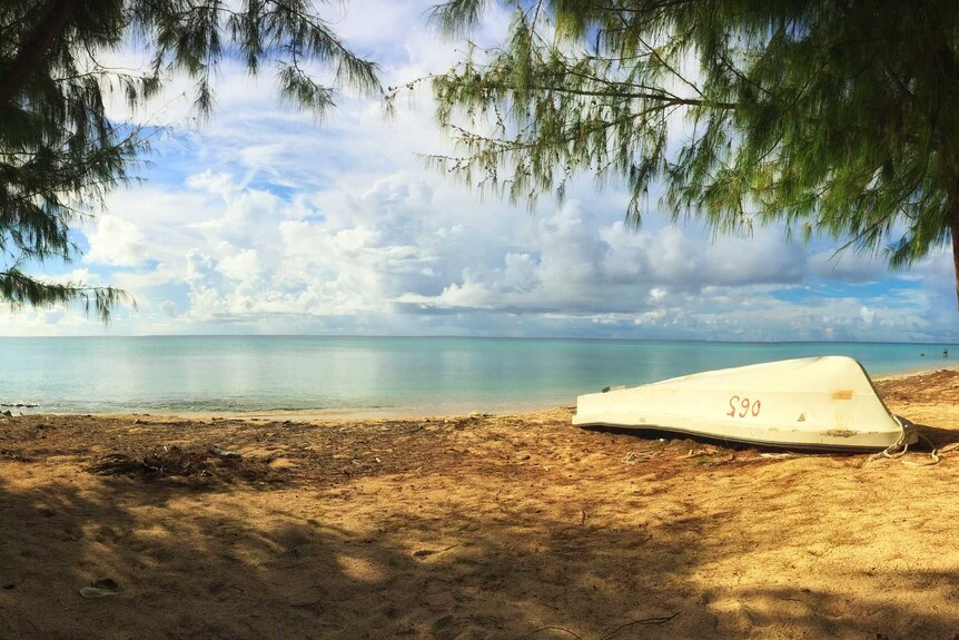 Enewetak lagoon on the Marshall Islands with upturned small boat on beach.