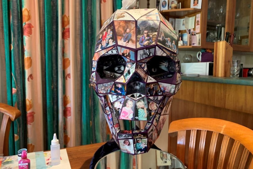 An ornament skull made with photographs of children and adults on the surface