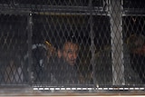 An activist arrested aboard a Gaza-bound ship looks out a bus window upon arrival at Ella prison