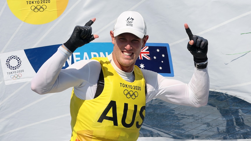 Australian sailor Matt Wearn points two fingers to the sky after winning a laser gold medal at the Tokyo Olympic Games.