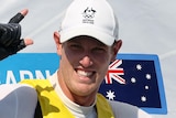 Australian sailor Matt Wearn points two fingers to the sky after winning a laser gold medal at the Tokyo Olympic Games.