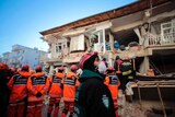Rescuers search for people buried under the rubble on a collapsed building.