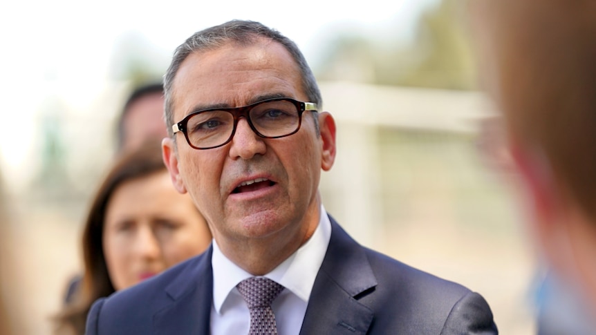 A man wearing a suit and tie and glasses