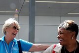 A member of the Oprah Winfrey audience is greeted at Sydney International Airport