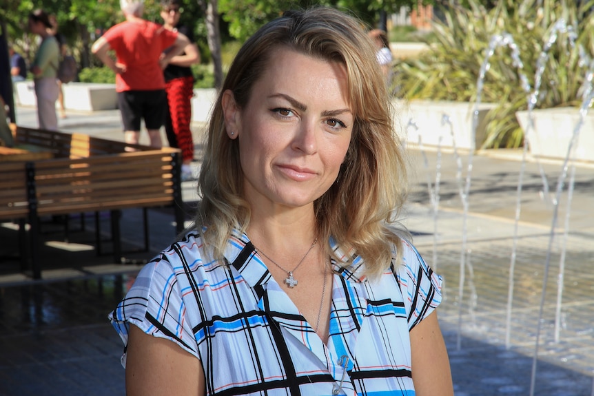 Eva Pears in pictured outdoors at a cafe with a fountain in the background