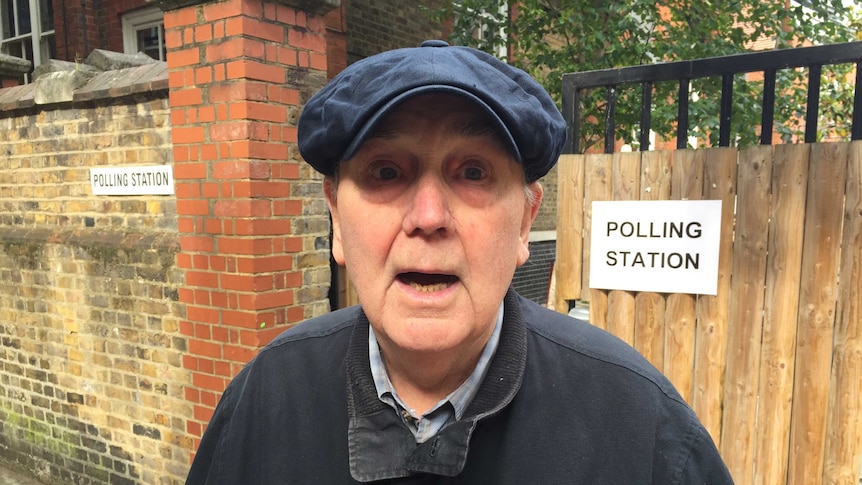 Voter James Howarth stands on the street in front of a polling station.