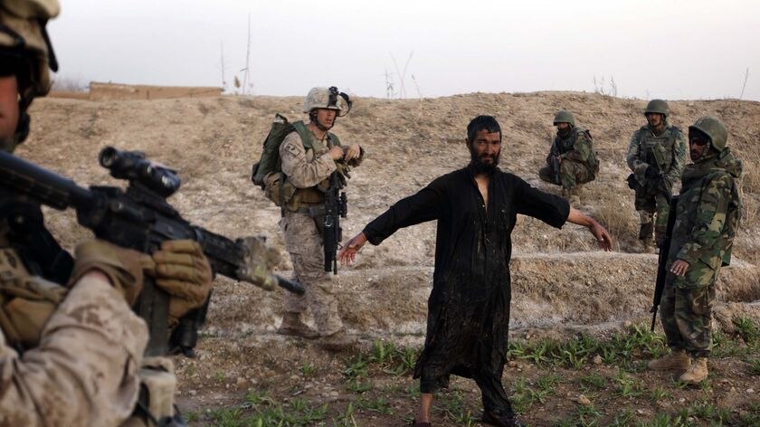 US troops  guard a man suspected to be a Taliban spotter. (Patrick Baz: AFP)