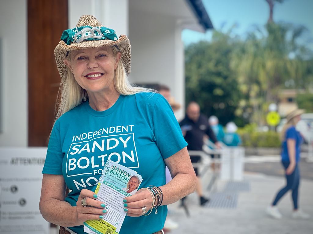 Una mujer con una camiseta verde y un sombrero.