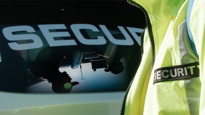 A security guard standing behind the back windscreen of a car.