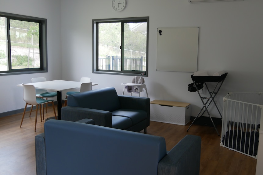 A living room with sofas, a dining table and a high chair for children