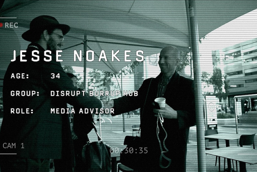 A camcorder graphic showing a man with shaved hair holding a coffee cup and shaking another man's hand