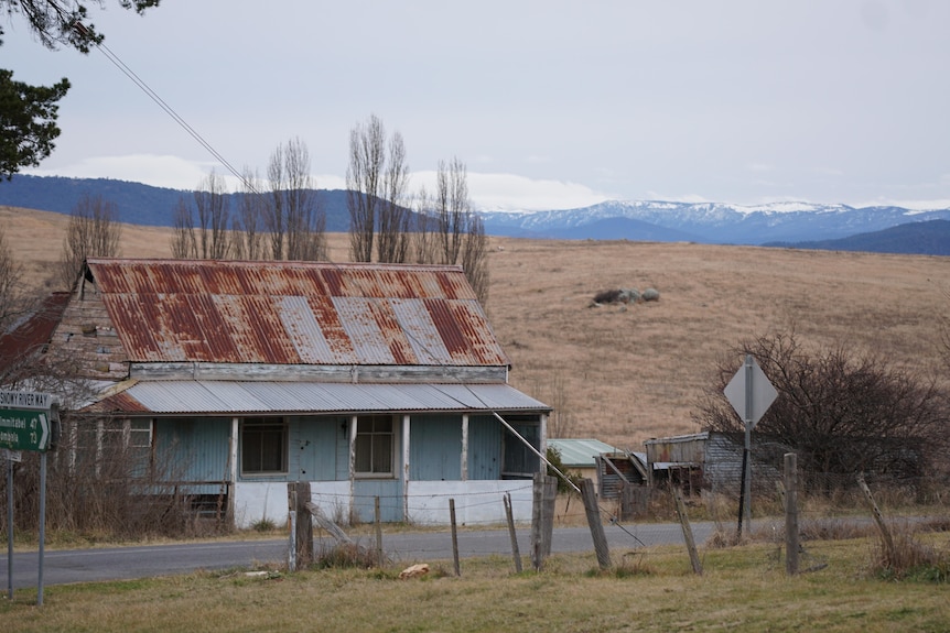 An old house with snowy alps in the background