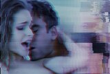 A blurred screenshot of a man nuzzling a woman's neck