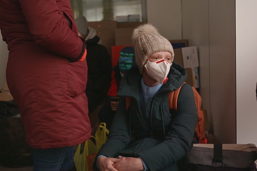 A young cancer patient in Kyiv waiting to be evacuated wearing a mask.