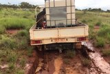 A ute gets bogged in a paddock at Tennant Creek
