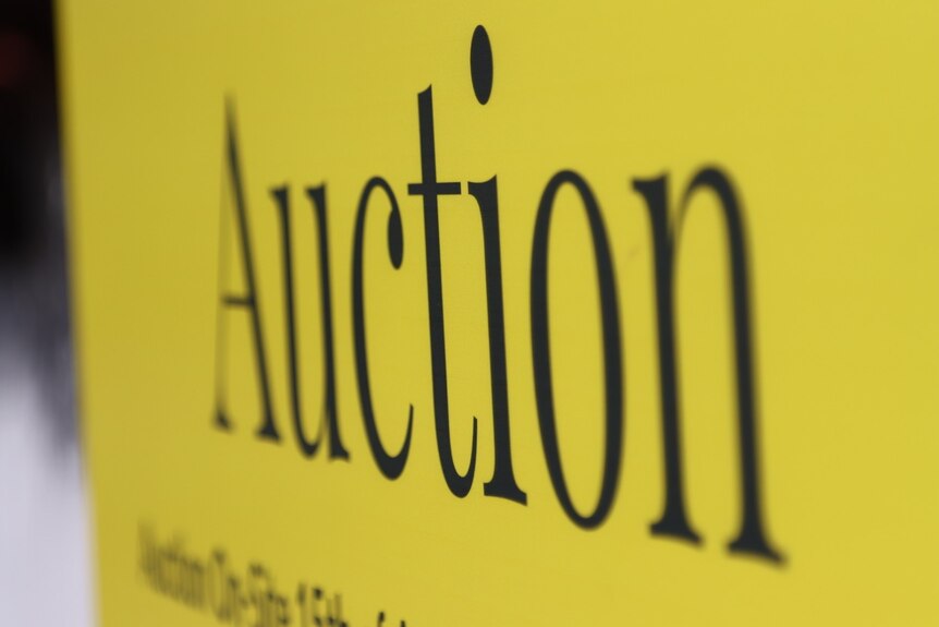 yellow real estate sign saying auction