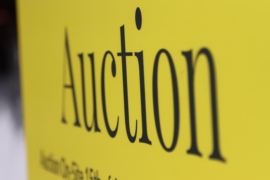 yellow real estate sign saying auction