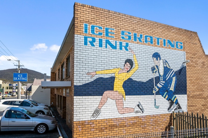 A sign on the side of an ice skating rink