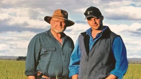 Two men standing in a field of wheat.