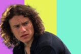 Heath Ledger in the 1990s movie 10 Things I Hate About You in front of a purple, yellow and aqua background wearing 90s fashion.