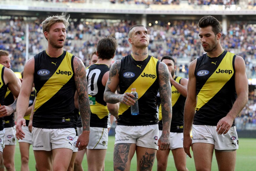 Dustin Martin (C) of the Tigers and teammates leave the field after a loss to West Coast in Perth.