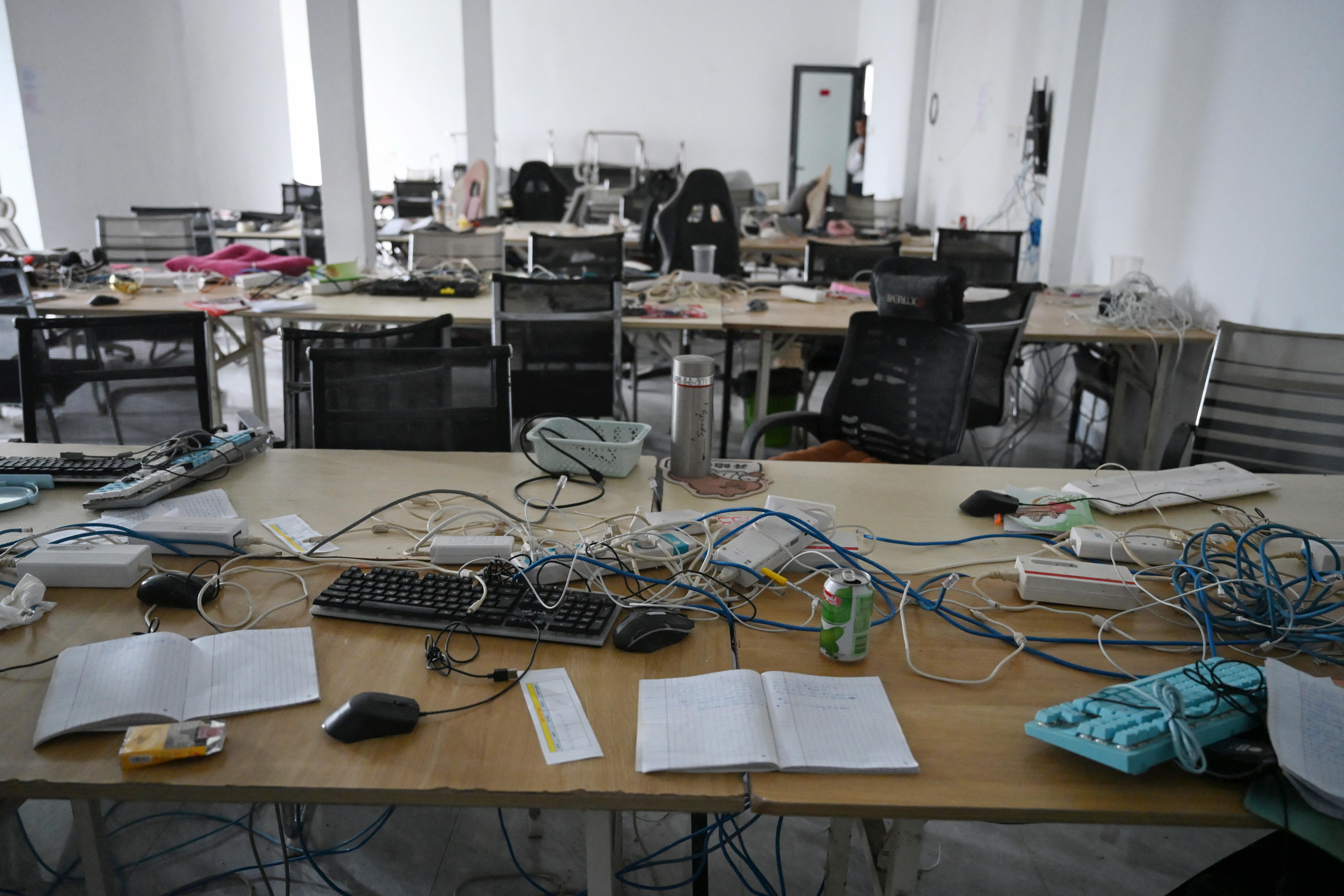 Abandoned equipment on desks in a room at a closed cyber scam centre