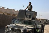 An Iraqi special forces soldier stands atop a Humvee in the village of Bazwaya.