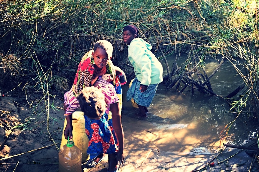 People taking water from a stream of the Kafue River