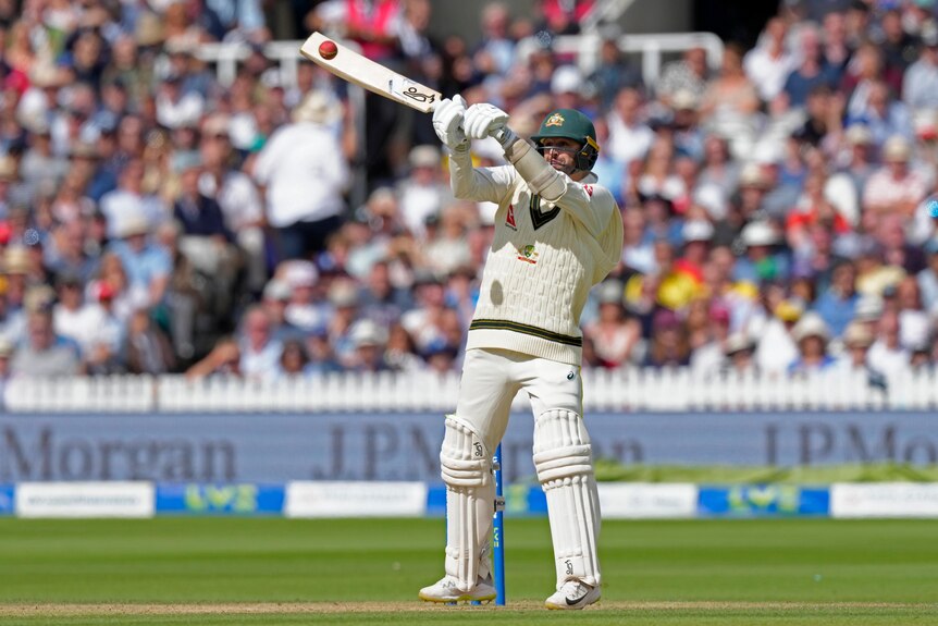 Australia batter Nathan Lyon swings at a high ball during an Ashes Test.
