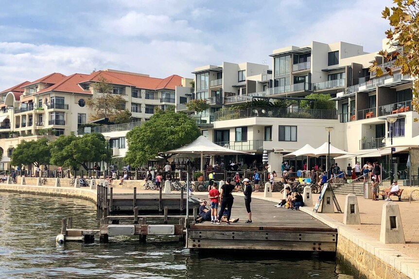 People milling about a riverfront inner-city precinct.