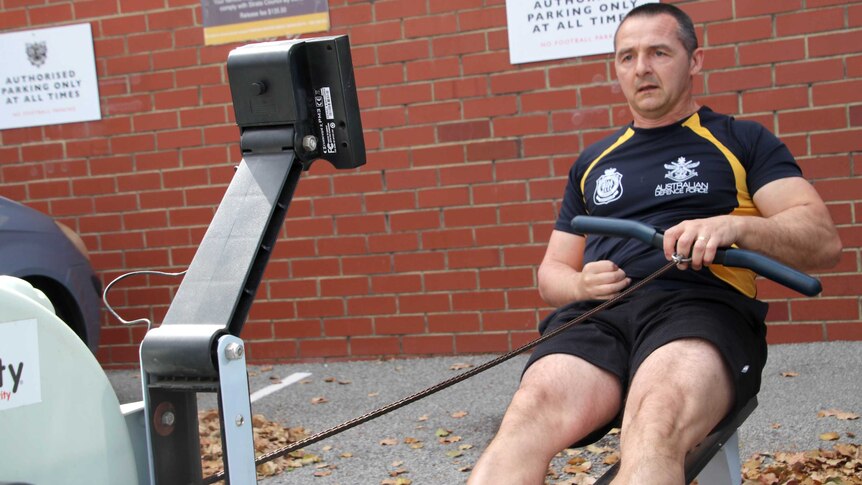 Former electronics warfare submariner in the Australian Navy Richard Wassell training on his rowing machine in the car park