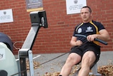 Former electronics warfare submariner in the Australian Navy Richard Wassell training on his rowing machine in the car park