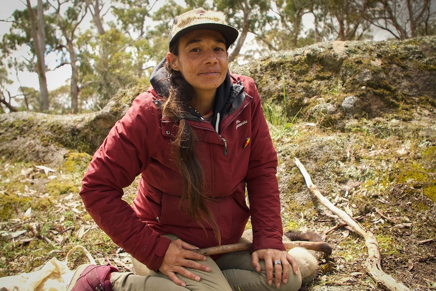 A woman sits on the ground.