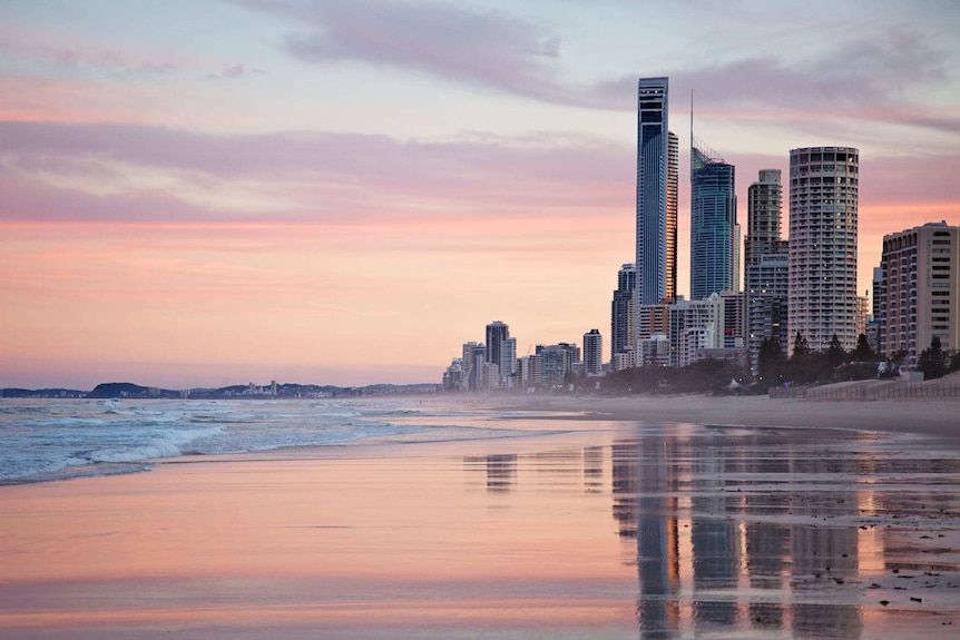 Gold Coast beach and high-rise building skyline during sunset.